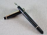 a pen and a ballpoint pen laying next to each other on a table