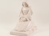 statue of a woman in a white robe and veil holding an umbrella