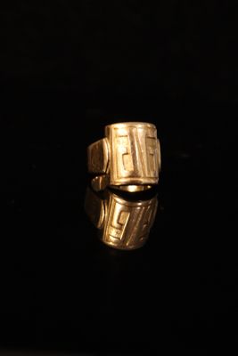 an image of a gold ring sitting on top of a black surface