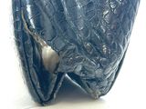 an image of a black purse on a white surface