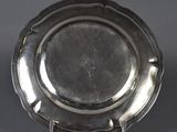 an antique silver plate on a stand on a grey background