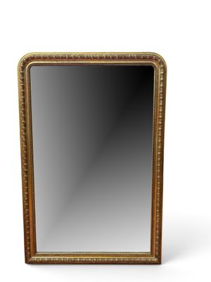 un miroir à cadre doré posé sur une surface blanche, avec un fond blanc