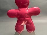 a pink sculpture of a man on a metal base