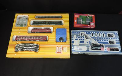 two boxed trains sitting on a table next to each other