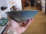 a person holding a bowl in their hand in a room