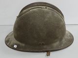 un vieux casque militaire est posé sur une surface blanche