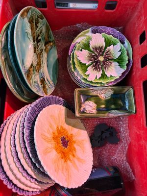 a red basket filled with assorted plates and bowls