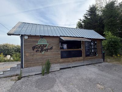 un petit bâtiment en bois sur lequel est accrochée une enseigne