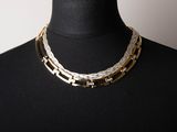 a close up of a mannequin wearing a necklace on a mannequin mannequin