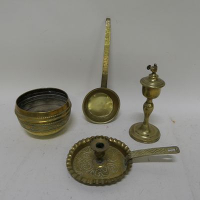 several antique brass objects including a candle, spoon, and measuring spoon