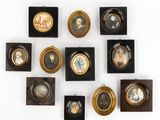 Plusieurs portraits encadrés de personnes sont accrochés au mur.