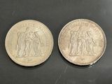 two silver coins, one of which is a woman and one of which is a man