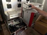 un homme debout à côté d'un carton contenant un ordinateur
