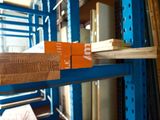 a stack of wood sitting on top of a shelf in a warehouse