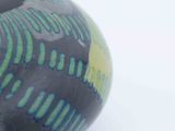 a black vase with blue and green designs on it