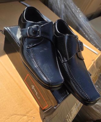 pair of men ' s shoes in a box on a cardboard box
