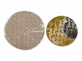 two round metal discs with different designs on them on a white surface