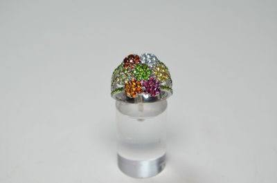 bague en argent ornée de pierres multicolores sur un fond transparent