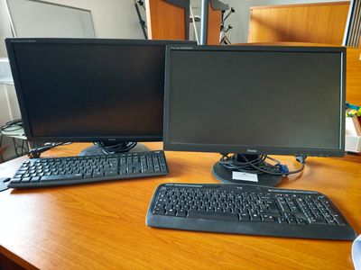 deux écrans d'ordinateur et un clavier sur un bureau