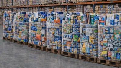 a large amount of soda cans stacked on pallets in a warehouse