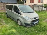 une camionnette grise garée dans l'herbe devant un immeuble