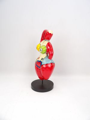 figurine of a man in a red suit sitting on top of a red apple