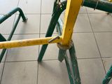 a yellow and green bicycle that is sitting on the ground