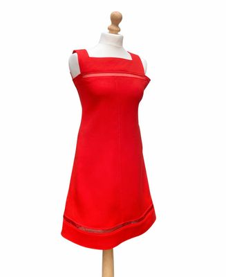 une robe rouge sur un mannequin, posée sur un fond blanc