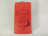 an old book sitting on top of a white table next to a brush