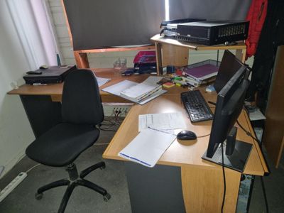 a desk with a computer, keyboard, mouse and other items on it