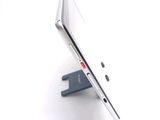 a silver laptop computer sitting on a stand on a white surface