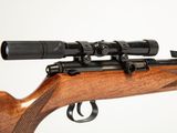 a close up of a rifle with a scope on a white background