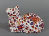une petite figurine représentant un chat orné de fleurs
