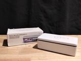 two white boxes sitting on top of a wooden table next to each other