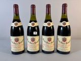 quatre bouteilles de vin sont alignées sur une table