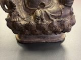 buddha statue on a table in a room with people in the background