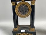 une paire de supports d'horloge noirs et dorés posés sur une surface blanche