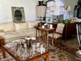 a living room with a couch, table, chairs, and a mirror