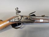 an old gun with a wooden handle on a white surface