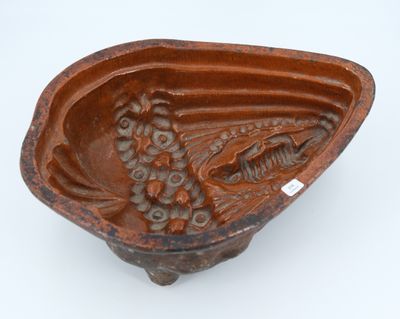 un bol marron contenant un poisson, posé sur une surface blanche