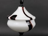 a black and white vase with a black top on a black table