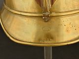 a gold helmet on a stand on a black background