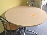 une table et des chaises dans une pièce où se trouve un tableau en liège accroché au mur