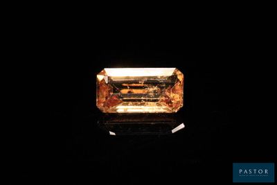 un diamant jaune dans l'obscurité, sur fond noir
