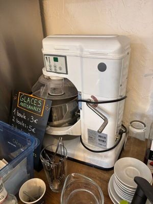 a coffee maker sitting on a counter next to a stack of dishes