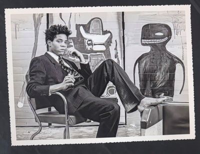 photographie en noir et blanc d'un homme en costume assis sur une chaise à côté d'un robot
