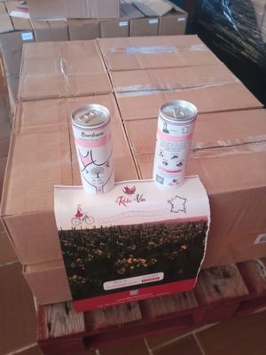 two cans of soda sitting on top of a cardboard box
