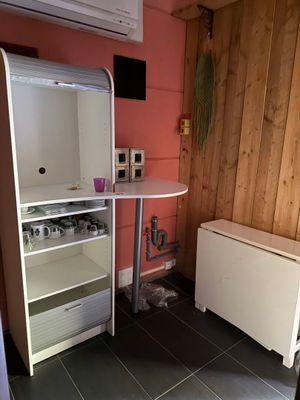 une petite cuisine équipée d'un réfrigérateur et d'une table