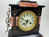 a clock that is sitting on a stand on a table