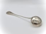 a silver spoon with a ball on it on a white surface